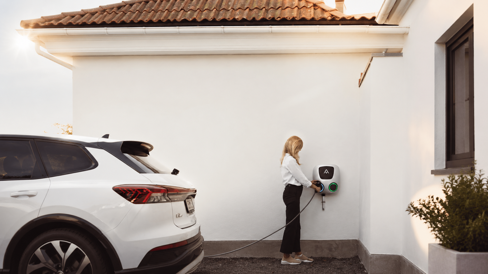 Charge Amps Aura beim Laden eines Elektroautos am Wohnhaus